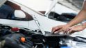 car-mechanic-using-laptop-computer-examining-tuning-fixing-repairing-car-engine-in-garage-.jpg